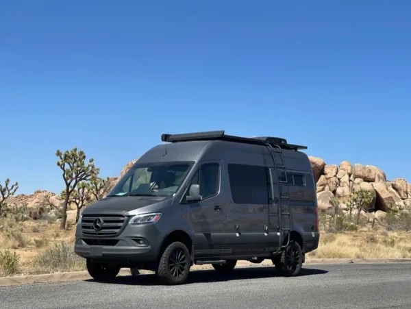 Storyteller Overland Stealth camper van parked on a rugged off-road trail