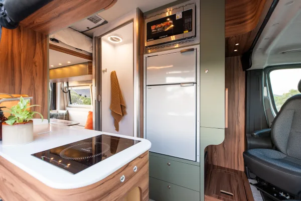 Noovo Plus camper van parked outdoors with all-terrain tires and rooftop solar panels